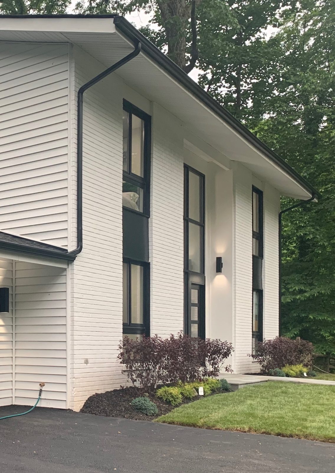 The same home after a total remodel in Oakton, Virginia, with painted brick, black-framed windows and new landscaping