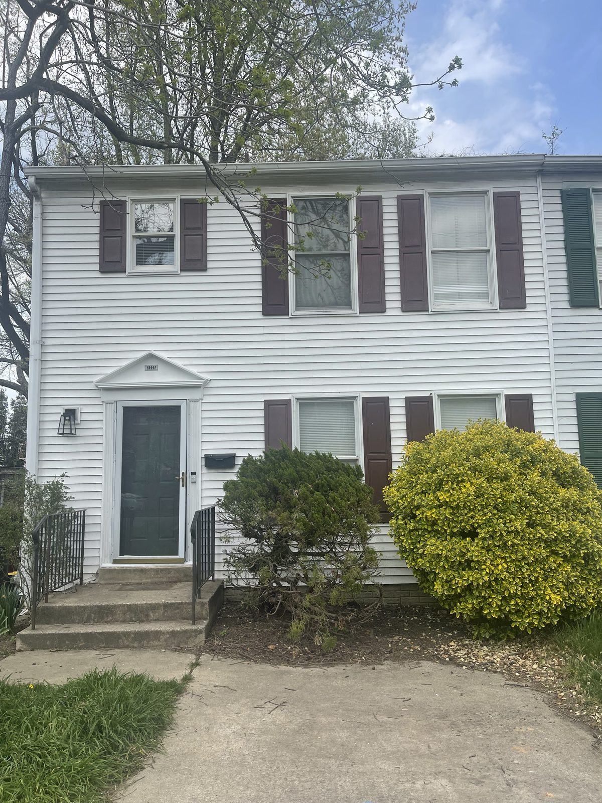 Home before a remodel and rear addition, with worn siding and dark shutters